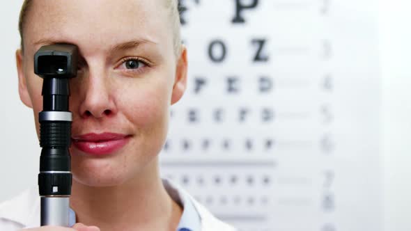 Female optometrist holding ophthalmoscope