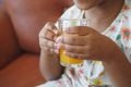 child hand holding a glass of orange juice  - PhotoDune Item for Sale