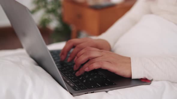 Close-up view of woman hands typing by laptop