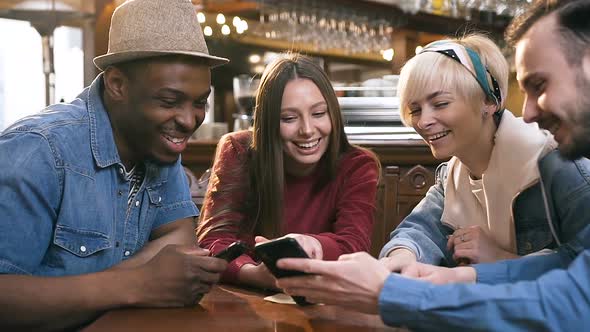 Group of Happy Hipster Friends Watching Video, Photo on the Smart Phone