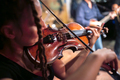 A female violinist plays the violin. Band performs on stage, rock music concert. - PhotoDune Item for Sale