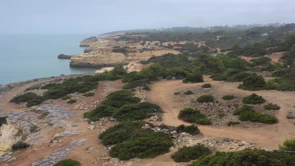 Fontainhas Beach Cliffs in South Portugal seen from the side, Aerial dolly in reveal shot