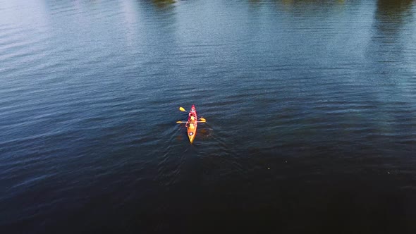 Two guys are canoeing on the river. Drone view.