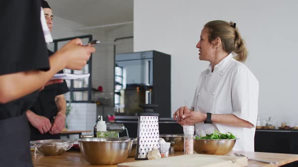 Caucasian female chef teaching diverse group