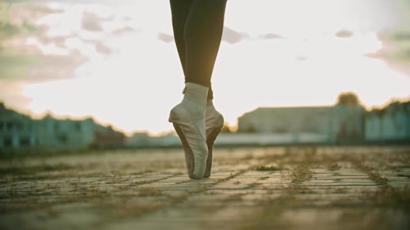 Legs of Young Woman Ballerina Slowly Walking on the Roof on Her Tiptoes