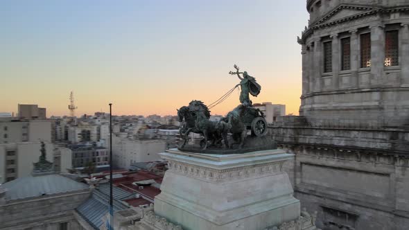 Aerial pan right of a bronze quadriga monument in front of Angrentine Congress Palace Dome at golden