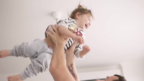 Slow Motion of Handsome Father Throwing His Adorable Daughter in the Air