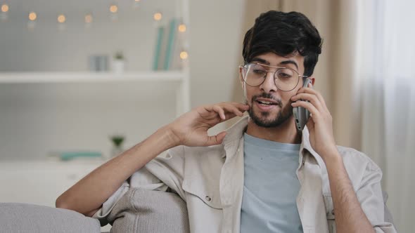 Bearded Man with Glasses Sitting on Sofa at Home Talking on Mobile Phone Call Chatting with Friends
