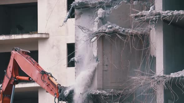 Destroying Old Concrete House Using Mechanical Arm of Bulldozer on Construction Site