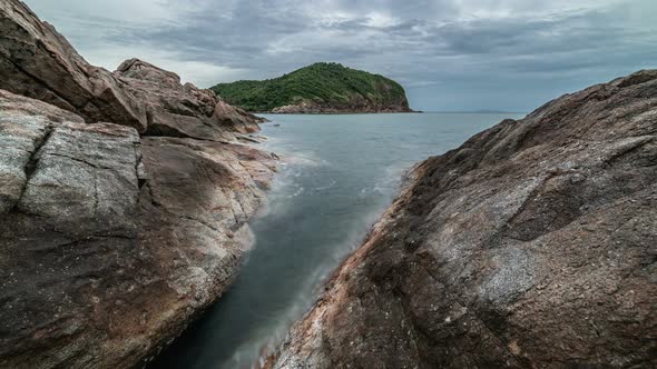 Dramatic rocky coastline at dusk and smooth sea wave