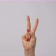 Woman raising two fingers up and showing peace or victory symbol or letter V - VideoHive Item for Sale