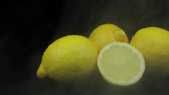 Tropical Fruit Lemon in Cold Ice Clouds of Fog Smoke on Black Background