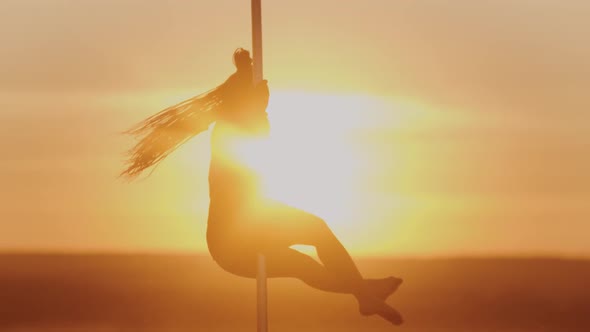 Pole Dance on Bright Sunset - Young Woman Spinning on the Dancing Pole