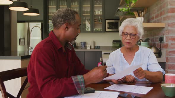 Senior African American husband and mixed race wife working together at home