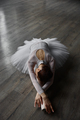 Young graceful ballerina dressed tutu posing on floor while training in studio - PhotoDune Item for Sale