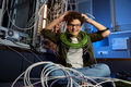 Stressed teenager geek wrapped in wire sitting on floor in data center - PhotoDune Item for Sale