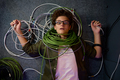 Frustrated overwhelmed teenager IT engineer lying on floor wrapped in wire - PhotoDune Item for Sale