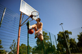 Skilled teenager basketball player jumping high throwing ball into basket - PhotoDune Item for Sale