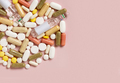 Mix of medical capsules and pills on light pink top view, copy space. Medicinal treatment - PhotoDune Item for Sale