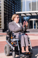 businesswoman using wheelchair typing on phone - PhotoDune Item for Sale