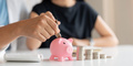 Family savings. Happy couple asian putting coin in piggybank while sitting together on desk at home - PhotoDune Item for Sale