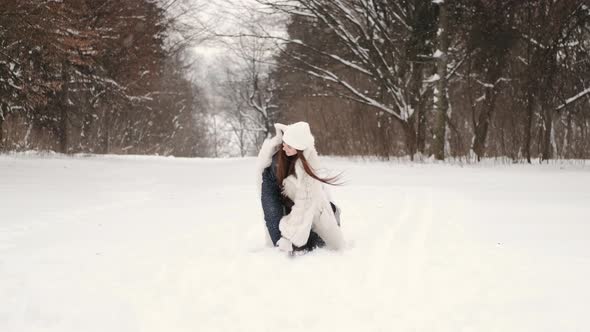 Mother Having Fun Sledding with Kids in Winter Forest