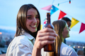 Portrait pretty young Caucasian woman toasting bottle beer in hand smiling. Attractive girl cheerful - PhotoDune Item for Sale