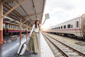 Asia woman traveller feeling happy go to travel and waiting for the on coming train at the train - PhotoDune Item for Sale