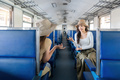 Two women friend talk and laugh while travel by train, railroad trip concept - PhotoDune Item for Sale