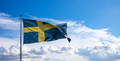 Sweden national flag waving on a flagpole, blue cloudy sky background - PhotoDune Item for Sale