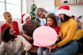 Surprised people opening Christmas presents at home. Happy and excited family gathered together. - PhotoDune Item for Sale