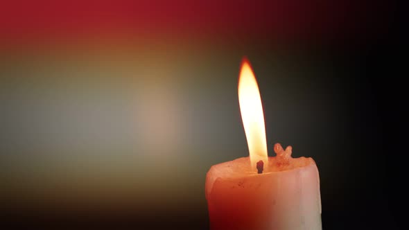 The showcases of colorful single candlelight on black background with the effect of light and slow m