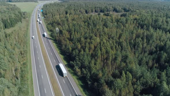 Convoy of Trucks Ride on the Highway Near Forest, Logistic Transportation, View of the Road From