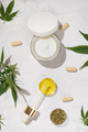 Cram jar, Pipette with CBD oil, capsules and Tea near green cannabis leaves. Alternative medicine - PhotoDune Item for Sale