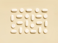 Mix of white medical pills in a line on light beige top view. Dietary supplements - PhotoDune Item for Sale