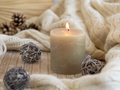 Burning candle near natural wooden decorations, Close up. Bohemian or scandinavian styled home - PhotoDune Item for Sale