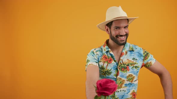 Latin Smiling Handsome Man Wearing a Beige Hat and a Hawaiian Shirt Giving a Present and a Rose