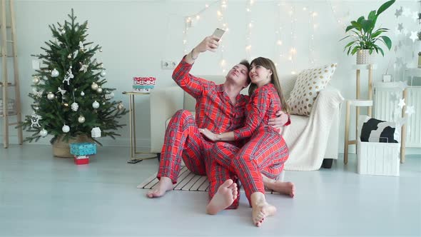 Loving Couple Taking Selfies Near Christmas Tree