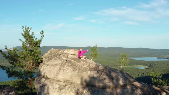 Aerial View of a Girl Doing Fitness and Yoga on a Rock