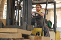 Male carpenter at wooden sawmill warehouse is loading with loader wooden board - PhotoDune Item for Sale