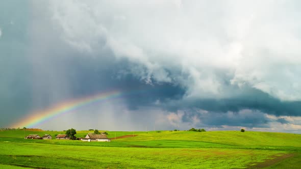 Rural landscape, rain clouds and rainbow