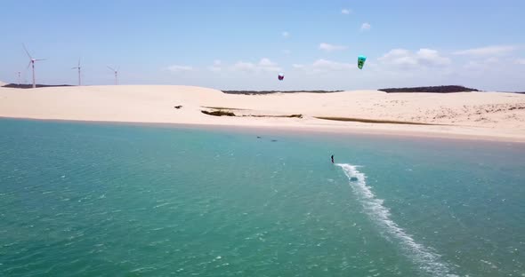 Aerial drone view of a man kiteboarding on a kite board in a lagoon lake