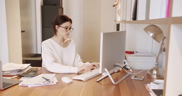 Young Business Woman in Glasses Working in Office Interior on Pc on Desk Typing