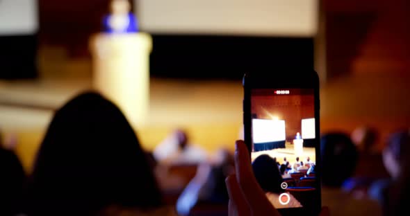 Businesswoman recording lecture during business seminar in auditorium 4k