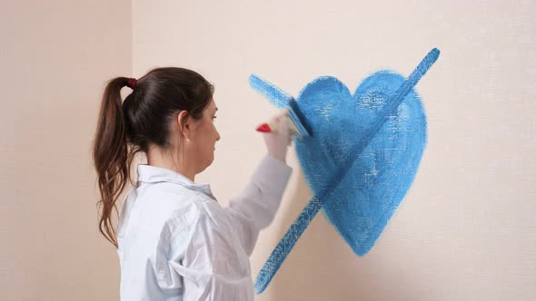 Angry Brunette with Hair in Ponytail Crosses Heart on Wall