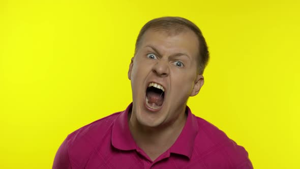 Portrait of Young Caucasian Man Posing in Pink T-shirt. Handsome Guy Screams and Gets Angry