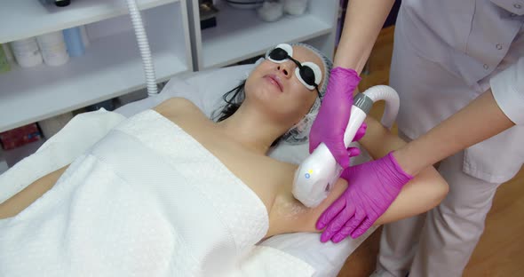 Laser Hair Removal In A Beauty Salon. The Procedure Of Epilation Under The Armpits By The Device