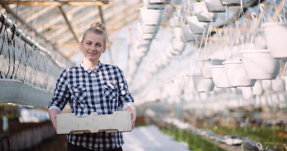 Agriculture Business - Smiling Gardener Working with Flowers in Greenhouse