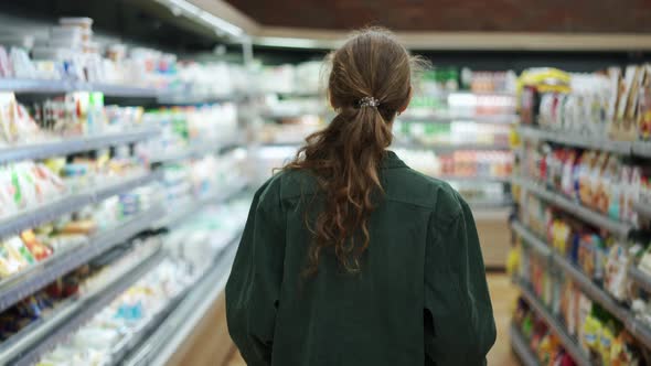 A Woman in a Supermarket Pushing Trolley Rear View