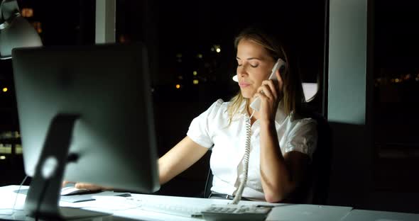 Businesswoman working over computer while talking on the phone